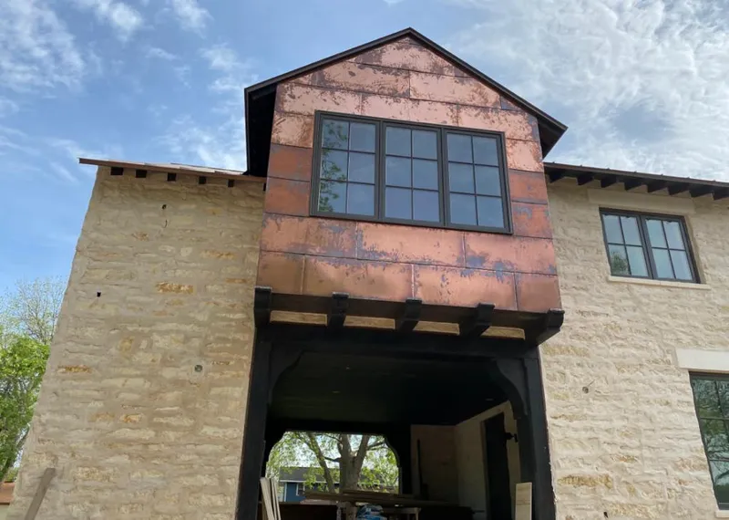 Copper metal panel facade on a stone building for Roof Repair in Lakeway